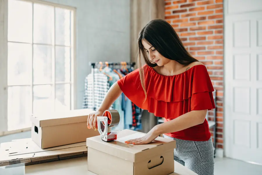 Mitarbeiterin verpackt Versandkarton für Fulfillment
